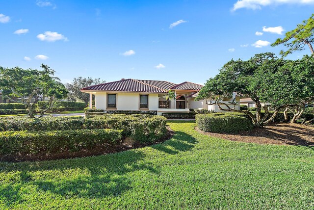 mediterranean / spanish house with a front lawn and a garage