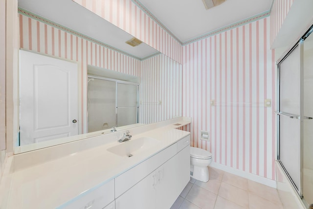 full bathroom with tile patterned floors, vanity, combined bath / shower with glass door, and toilet