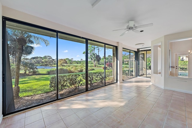 unfurnished sunroom with a water view and ceiling fan