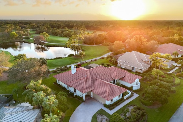 aerial view at dusk featuring a water view