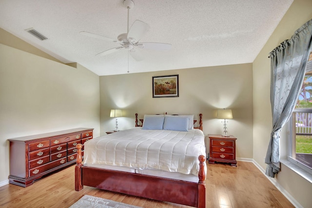 bedroom with ceiling fan, light wood-type flooring, a textured ceiling, and vaulted ceiling