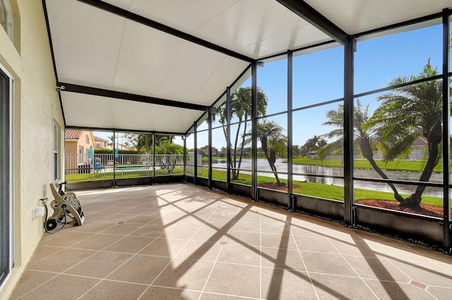 unfurnished sunroom featuring a water view and lofted ceiling