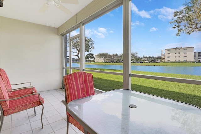 sunroom / solarium featuring ceiling fan and a water view