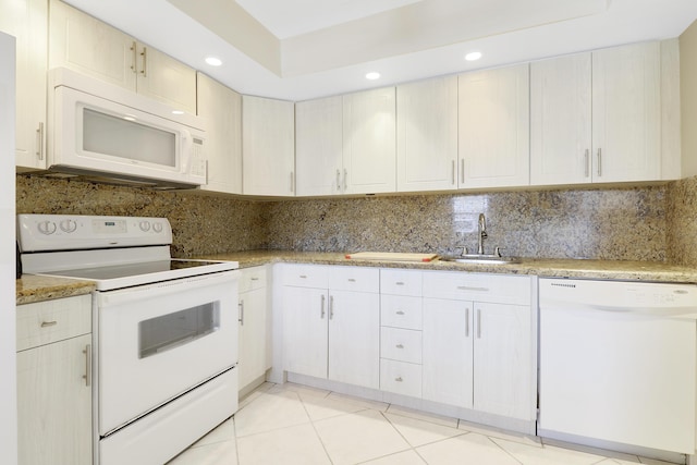 kitchen featuring tasteful backsplash, sink, light tile patterned floors, and white appliances