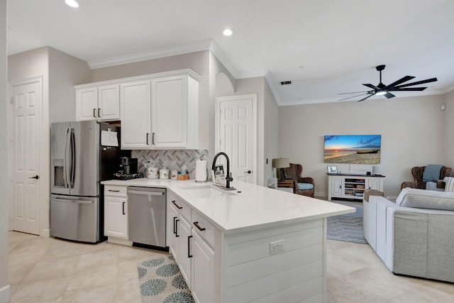 kitchen with tasteful backsplash, sink, white cabinets, and stainless steel appliances