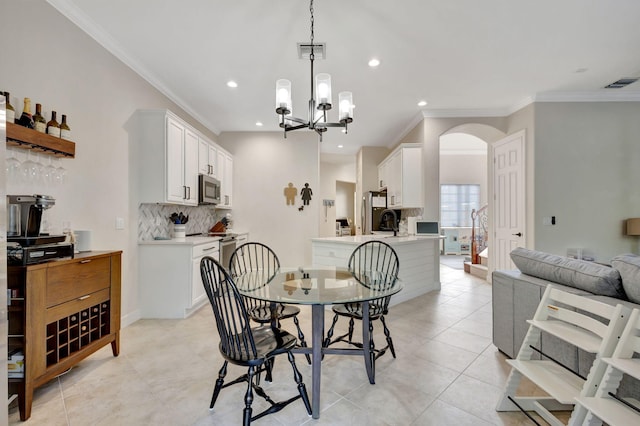 dining space with a notable chandelier, ornamental molding, and light tile patterned floors