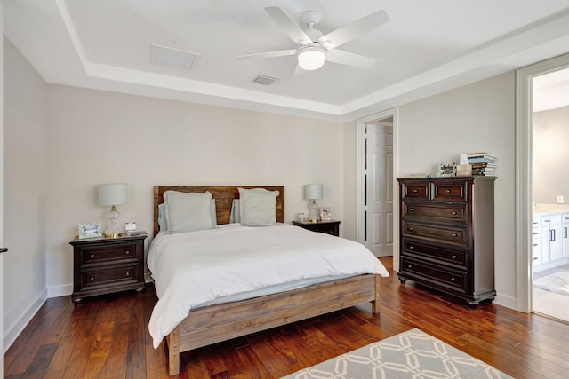 bedroom featuring a raised ceiling, ceiling fan, and dark wood-type flooring