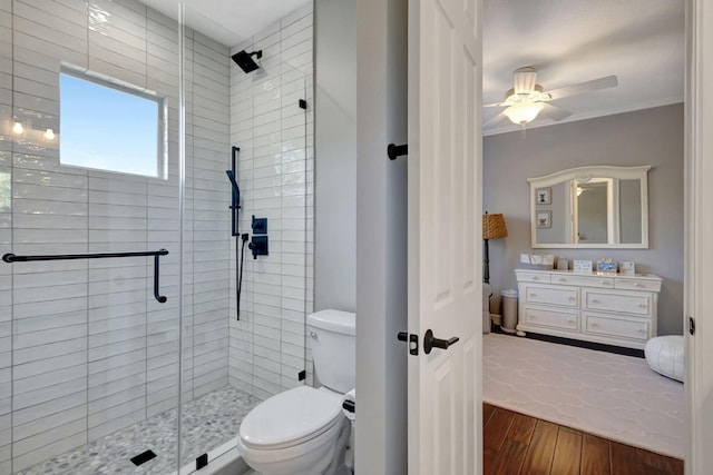 bathroom with vanity, hardwood / wood-style flooring, ceiling fan, toilet, and a shower with shower door