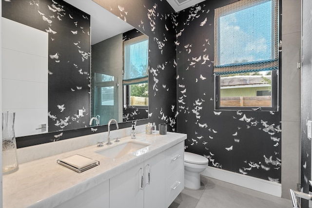 bathroom featuring tile patterned flooring, vanity, toilet, and walk in shower