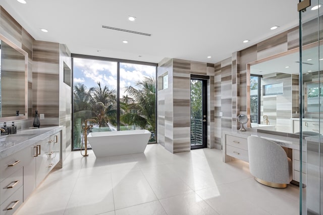 bathroom with a wall of windows, tile patterned flooring, shower with separate bathtub, vanity, and tile walls