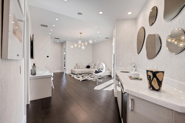 interior space featuring a chandelier, sink, and dark wood-type flooring