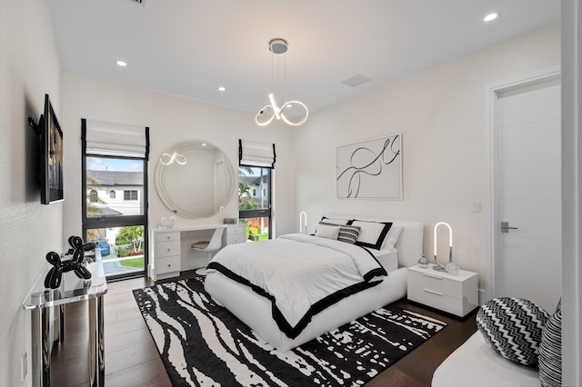 bedroom with wood-type flooring and a notable chandelier