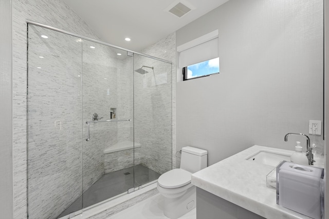 bathroom with vanity, toilet, and a shower with shower door