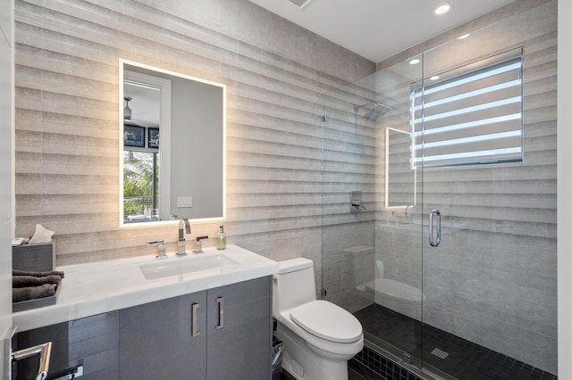 bathroom with walk in shower, vanity, and toilet