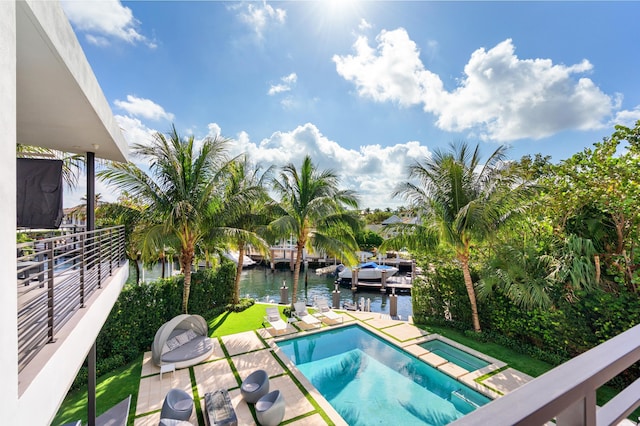 view of swimming pool with a water view and a patio area