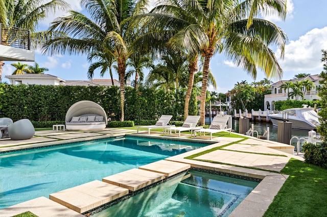 view of swimming pool with an in ground hot tub, a water view, and a patio