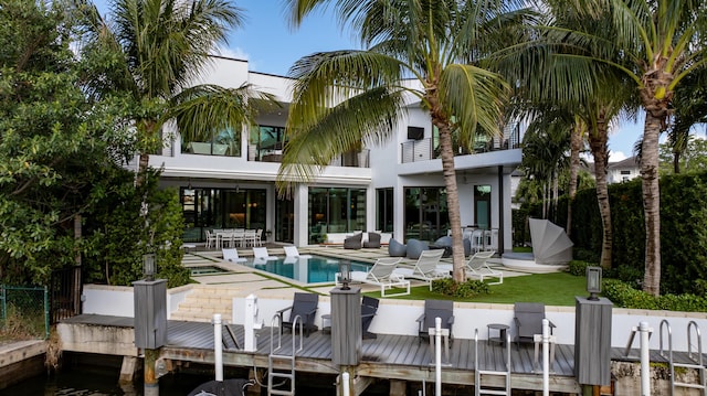 back of house featuring an outdoor living space, a balcony, a fenced in pool, and a patio