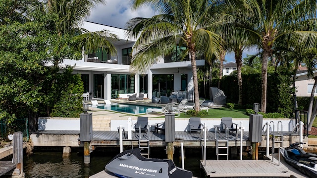 rear view of house with a fenced in pool, a patio area, a balcony, and a water view