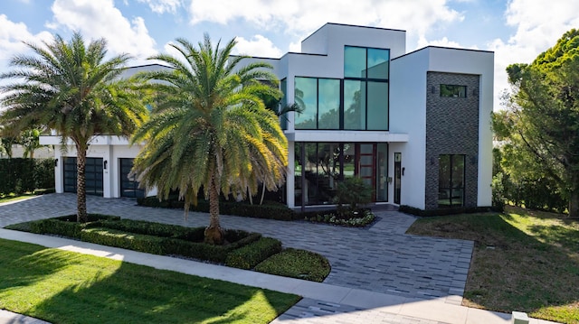 modern home featuring a garage and a front lawn