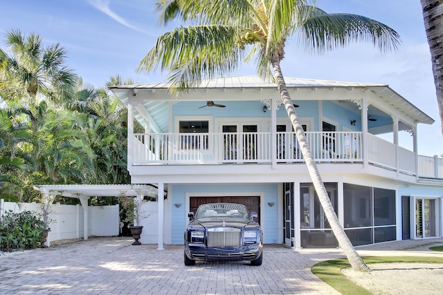 view of front of home featuring ceiling fan, a sunroom, and a garage