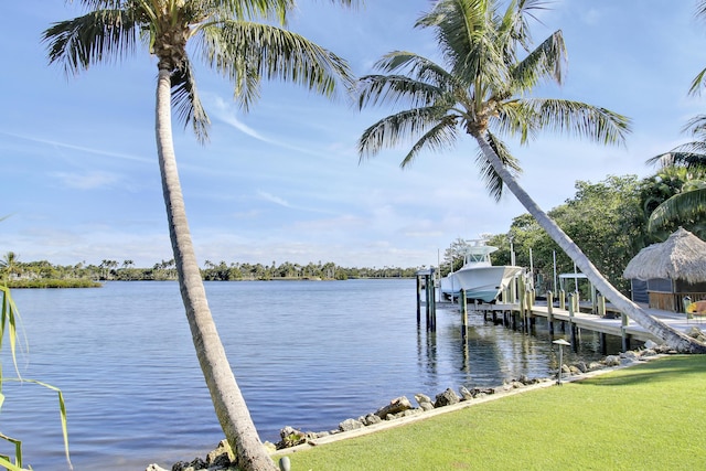 view of dock with a water view and a lawn