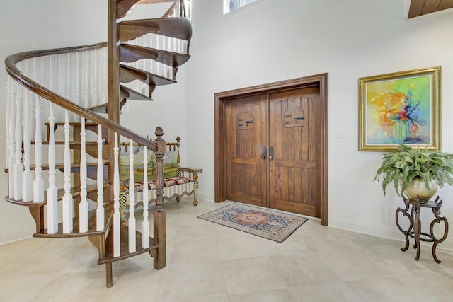 tiled entryway with a towering ceiling