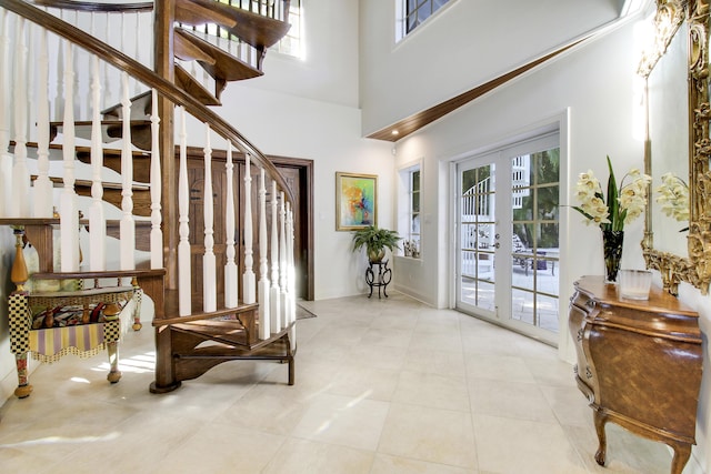 entryway with a towering ceiling and french doors