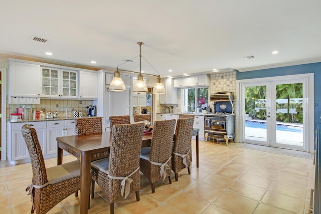 tiled dining space featuring french doors, crown molding, and plenty of natural light