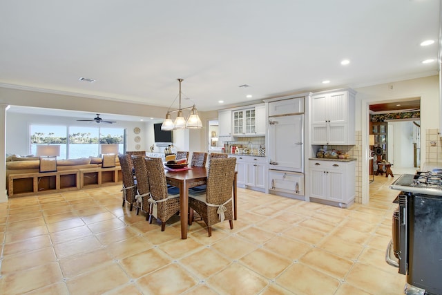 tiled dining room featuring ceiling fan and ornamental molding