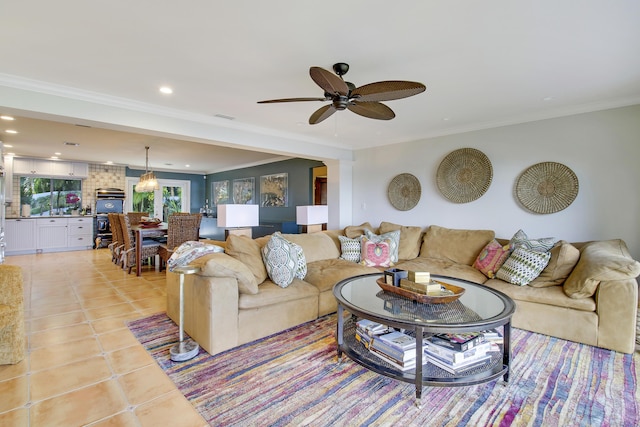 living room featuring ceiling fan, light tile patterned flooring, and ornamental molding