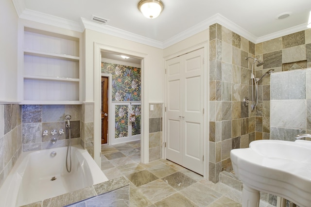 bathroom with sink, tile walls, ornamental molding, and tiled shower / bath