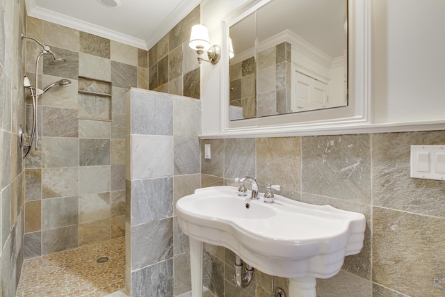 bathroom with backsplash, tiled shower, tile walls, crown molding, and sink