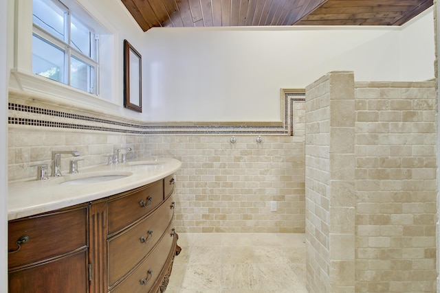 bathroom with vanity, wood ceiling, and tile walls