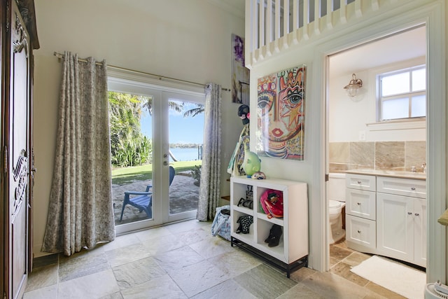 doorway featuring sink, a water view, and french doors