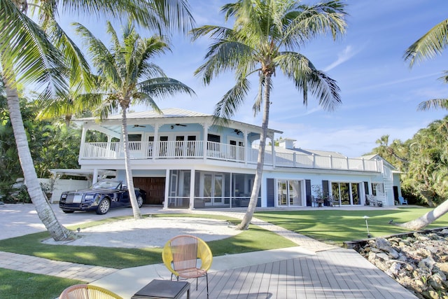 back of house featuring a balcony and a yard