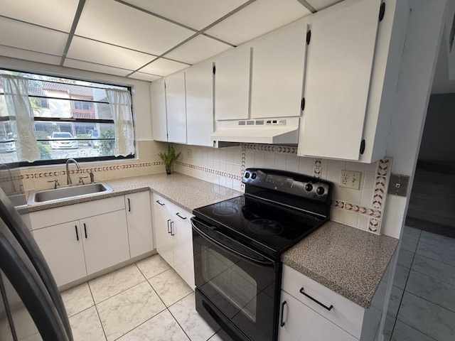 kitchen featuring black range with electric stovetop, decorative backsplash, a sink, and under cabinet range hood