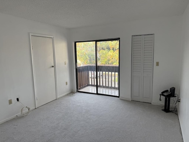 carpeted empty room featuring a textured ceiling