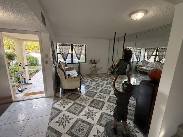 interior space featuring a textured ceiling and light tile patterned floors