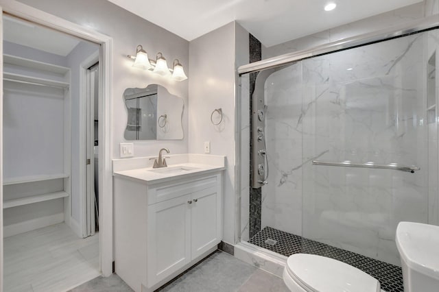 bathroom with vanity, toilet, and a shower with shower door