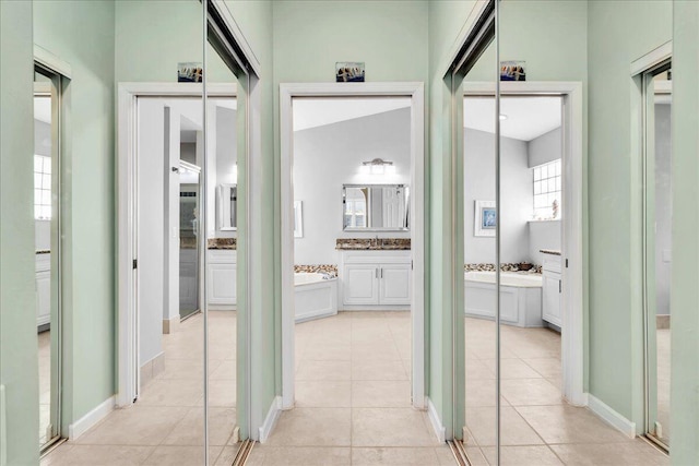 corridor with light tile patterned floors and sink