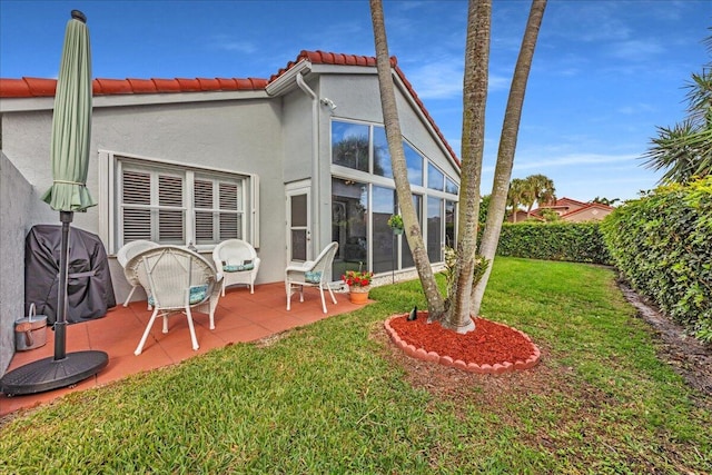 back of property featuring a lawn and a patio