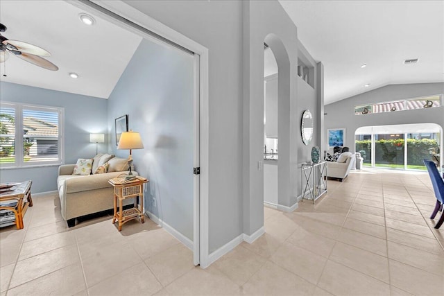 hall featuring light tile patterned flooring and lofted ceiling