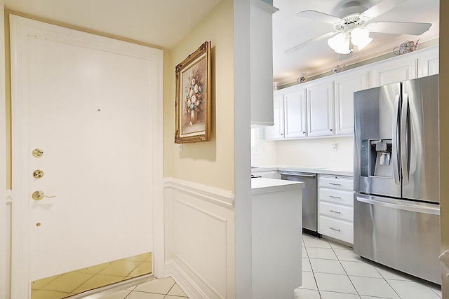 kitchen featuring white cabinets, appliances with stainless steel finishes, light tile patterned floors, and ceiling fan