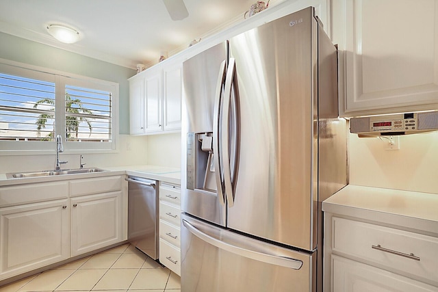 kitchen with sink, white cabinets, light tile patterned flooring, and appliances with stainless steel finishes