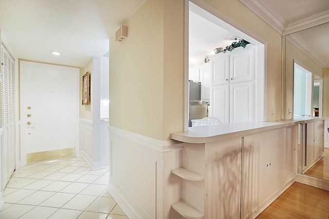 hall featuring crown molding and light tile patterned floors