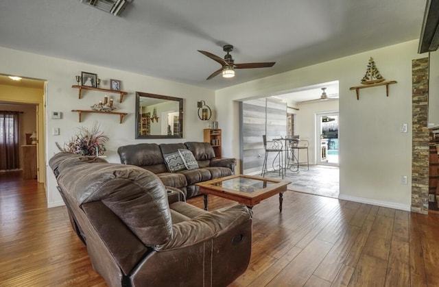 living room with ceiling fan and dark wood-type flooring