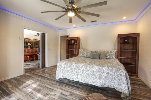 bedroom with dark hardwood / wood-style floors, ceiling fan, and crown molding