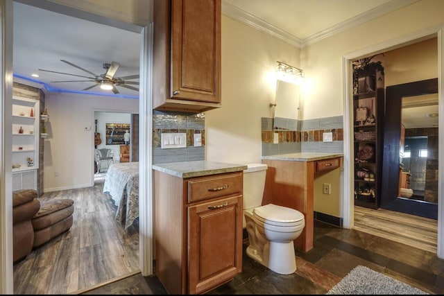 bathroom featuring decorative backsplash, crown molding, ceiling fan, and wood-type flooring