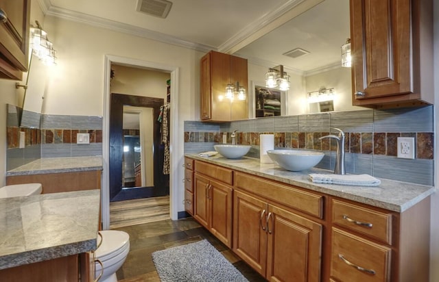 bathroom featuring backsplash, crown molding, vanity, and toilet