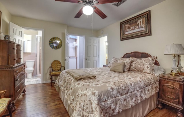 bedroom featuring ceiling fan, dark hardwood / wood-style floors, and ensuite bath